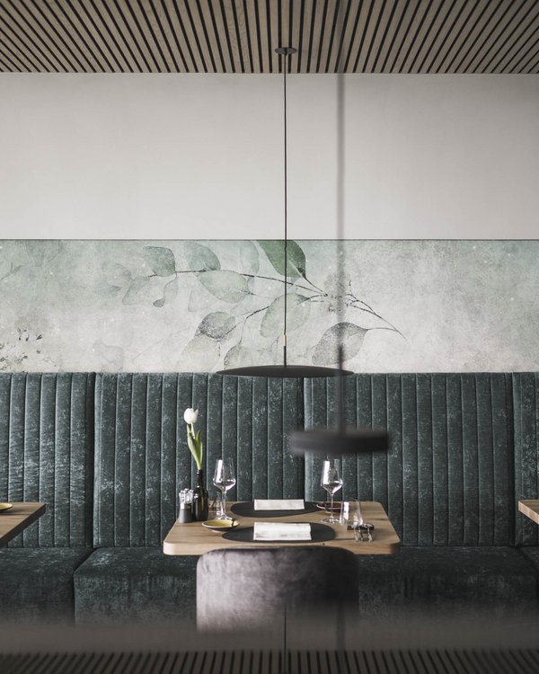 Accommodation in Dorf Tirol? SomVita Suites! Modern restaurant with green benches and set wooden tables